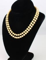 A vintage two strand cultured pearl necklace - mid-20th century, with golden toned 6mm pearls and