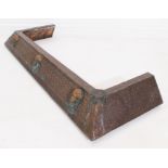 An Edwardian hammered copper fire curb - of bevelled form, decorated with three classical masks