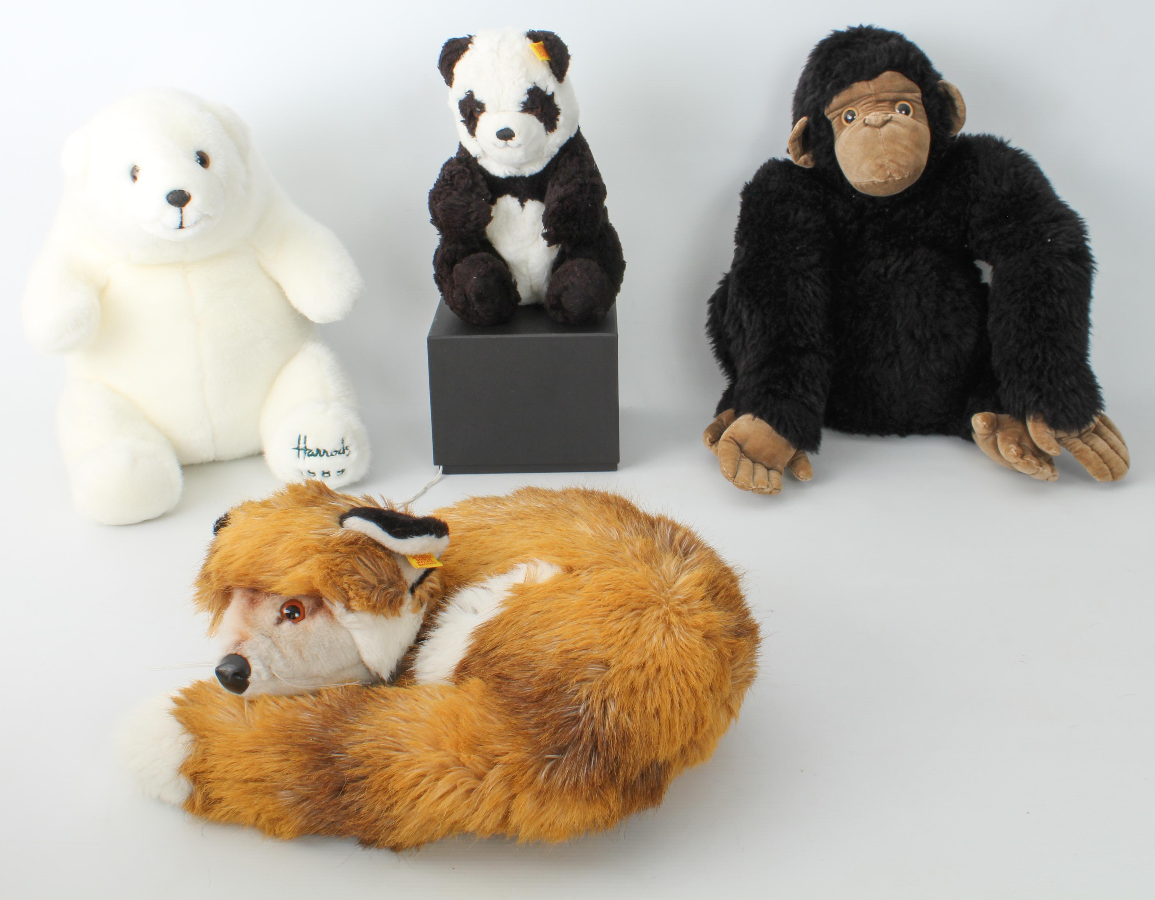 Two Steiff soft toys - comprising a sleeping fox (ref. 1542/35) and a seated panda (ref. 5357/25),