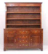 A George III oak, fruitwood and birds' eye maple inlaid dresser - the cavetto cornice over a