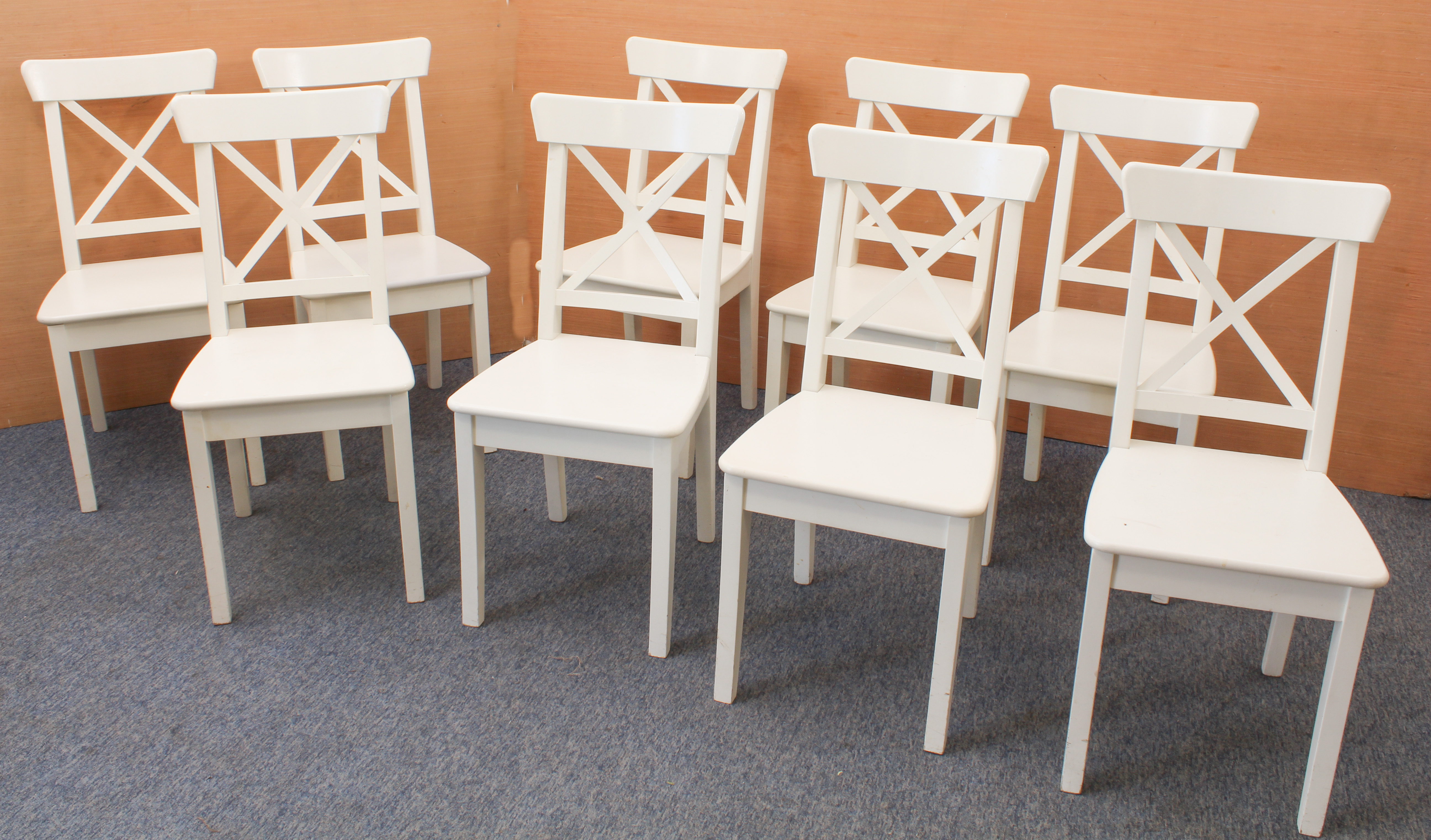 A set of nine Ikea 'Ingolf' white-painted dining chairs - with X-shaped backs and solid seats, on