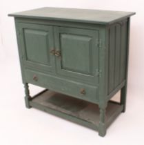 A dark-green painted shabby-chic-style side cabinet: the overhanging top above two fielded panel