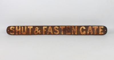 A cast iron 'Shut & Fasten Gate' railway sign - painted black with white lettering, 80.5 cm long.