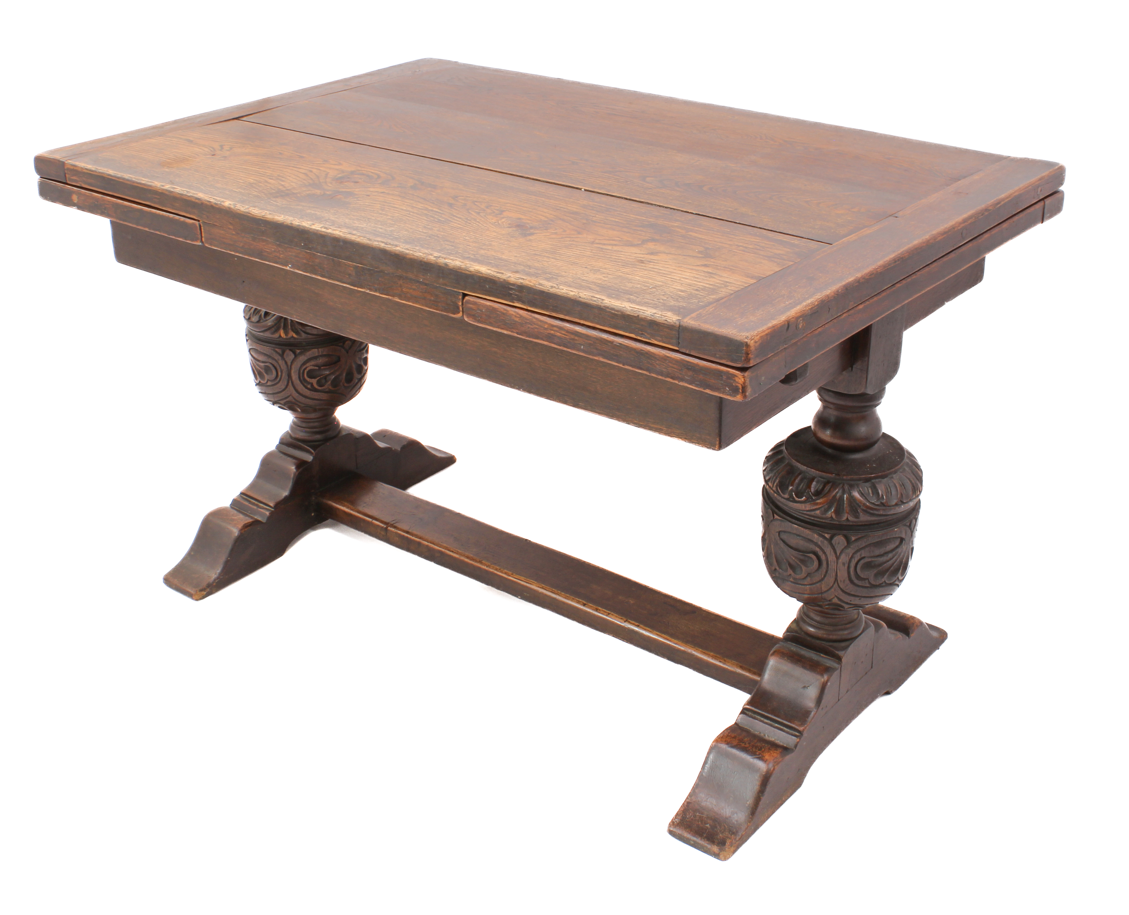 A carved oak extending refectory style dining table - the cleated, rectangular top with a single