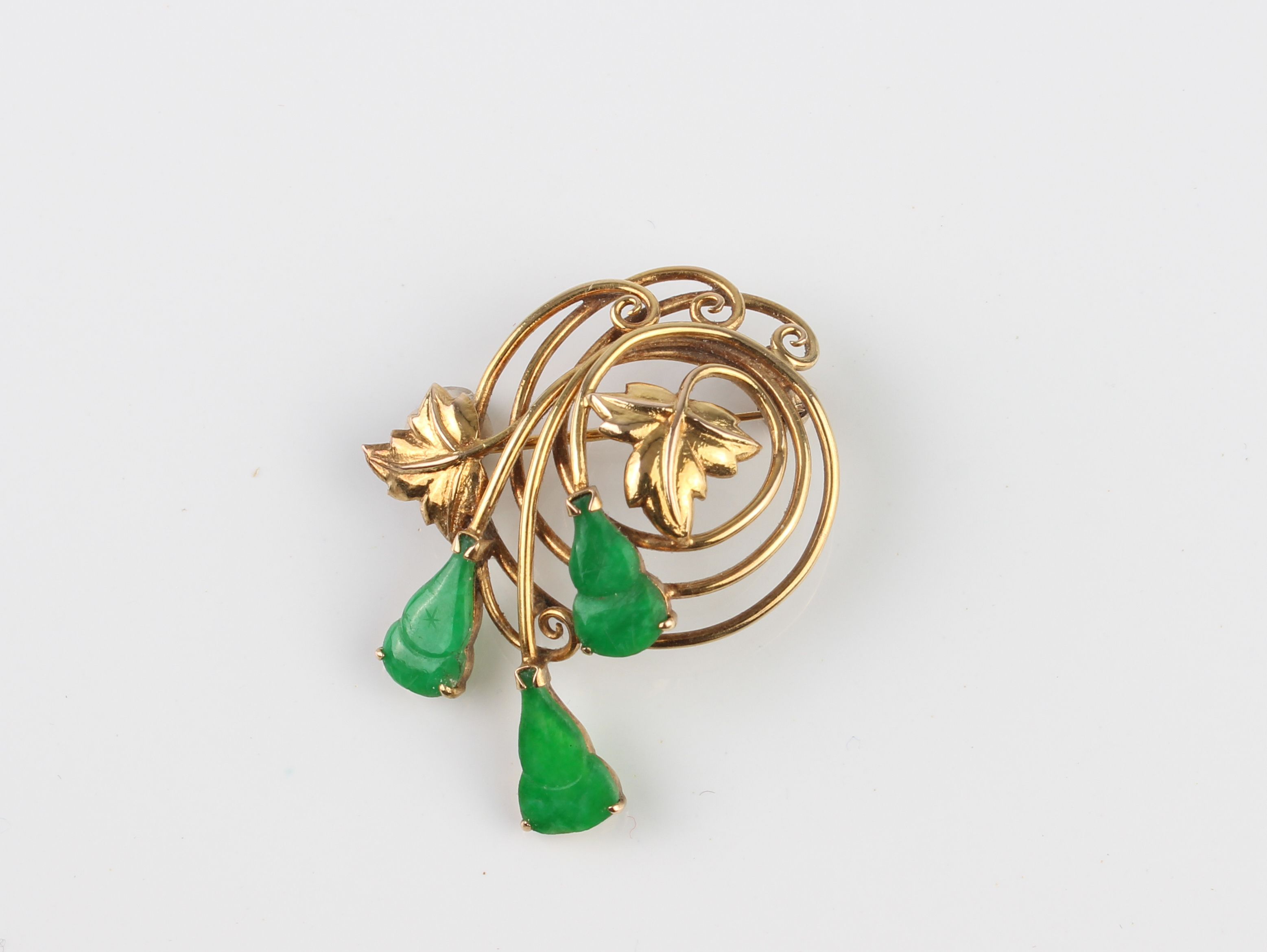 A Chinese 14ct yellow gold and jade brooch - stamped '14K', in the form of a spiralling bouquet with