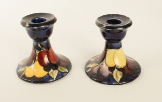 A closely matched pair of Moorcroft dwarf candlesticks in the 'Wisteria' pattern - impressed factory