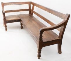 An 18th century and later oak corner settle - the two rail back over a solid two-plank seat and