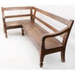 An 18th century and later oak corner settle - the two rail back over a solid two-plank seat and