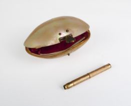 A Victorian mother-of-pearl shell purse - oval with gilt metal clasp and claret silk lining,