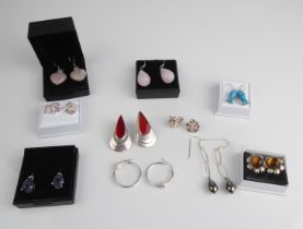 Nine pairs of silver earrings, most gemstone set.