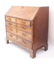 A George III mahogany bureau - the fall front enclosing a well fitted interior with central inlaid