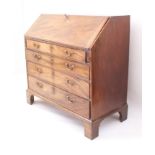 A George III mahogany bureau - the fall front enclosing a well fitted interior with central inlaid