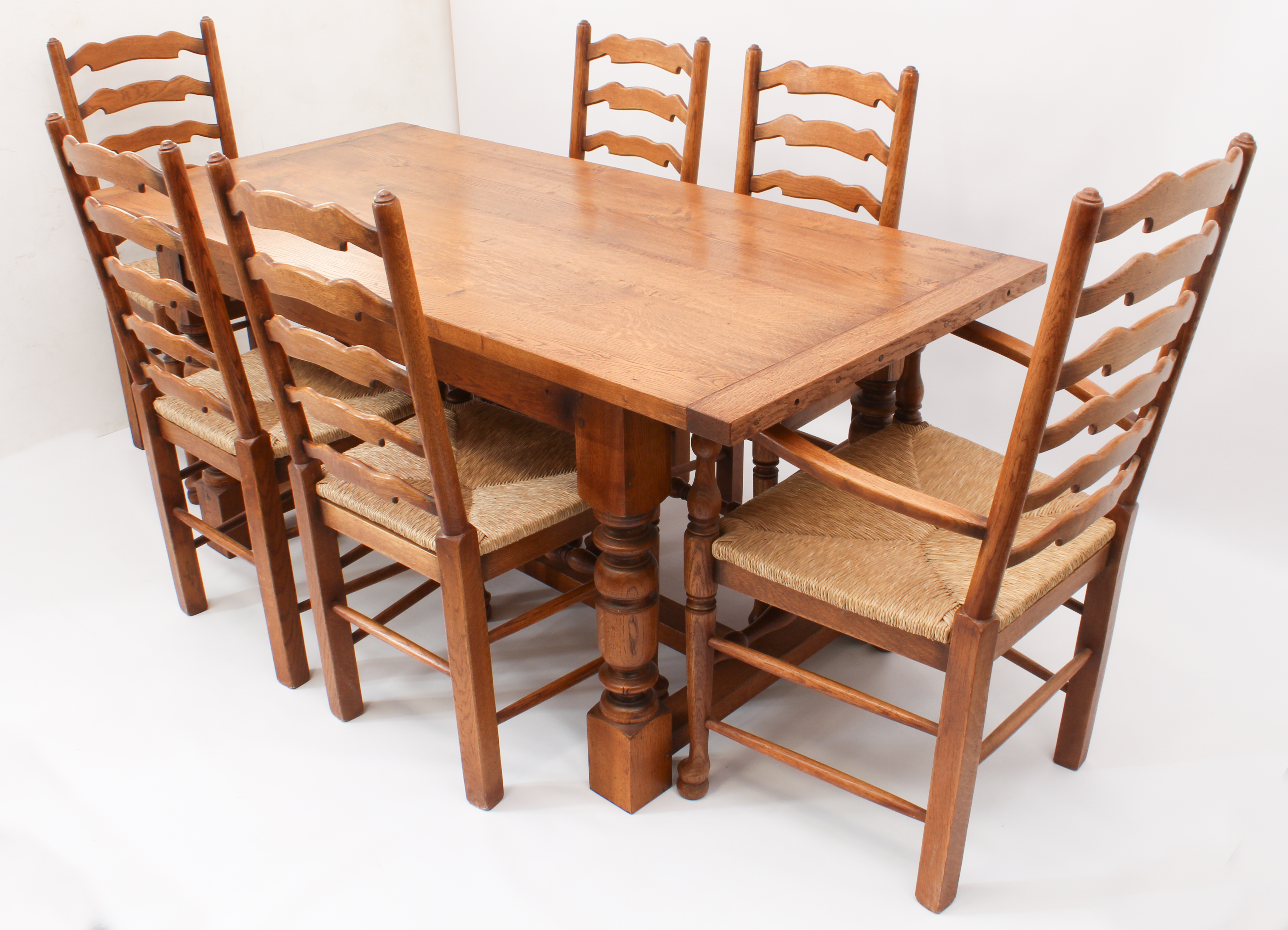 An oak extending refectory style dining table and six ladderback chairs - in the 18th century style,