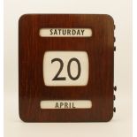 A mid-20th century wall-hanging perpetual calendar - in a stained plywood case with brass button-