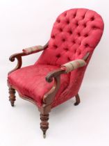 A mid-19th century walnut open armchair - the button back and serpentine seat in deep pink floral