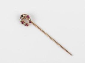 An antique 9ct yellow gold, ruby and diamond horseshoe stick pin - with rose gold pin, one ruby