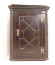 A mid-18th century oak corner cupboard - gold colour, the stepped cornice with carved egg and dart