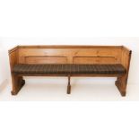 A Victorian pine pew - the chamfer-panelled back with a trefoil shaped handrail above, over a