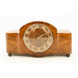 An Art Deco walnut-cased mantel clock - 1940s-50s, the serpentine, broken-arch case with Arabic,