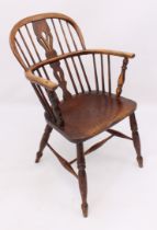 An early 19th century ash and elm Windsor arm chair - with double pierced vase splat, curved arms on