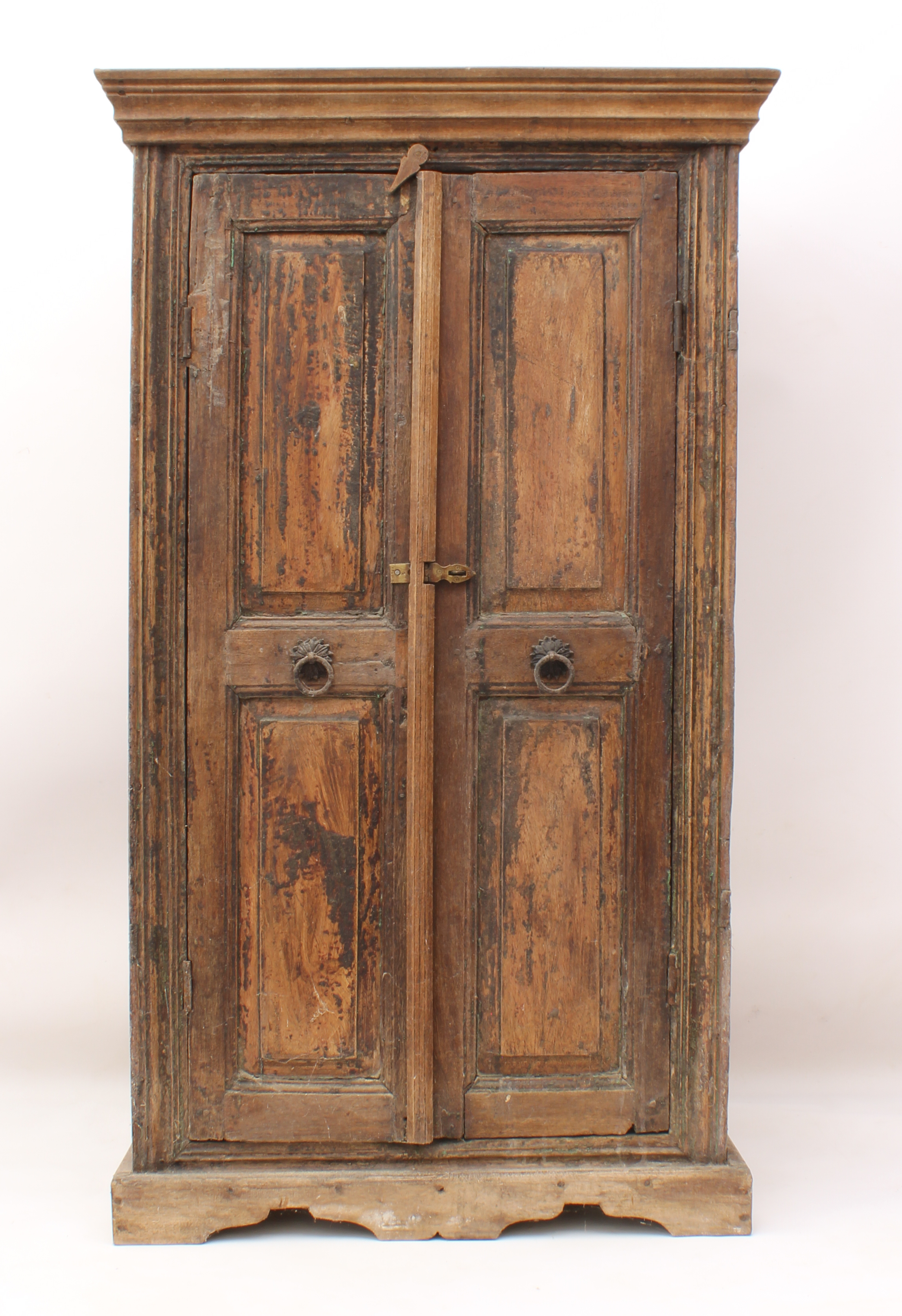 An Indian panelled hardwood cupboard - early 20th century, the later flared, moulded cornice over