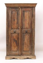 An Indian panelled hardwood cupboard - early 20th century, the later flared, moulded cornice over