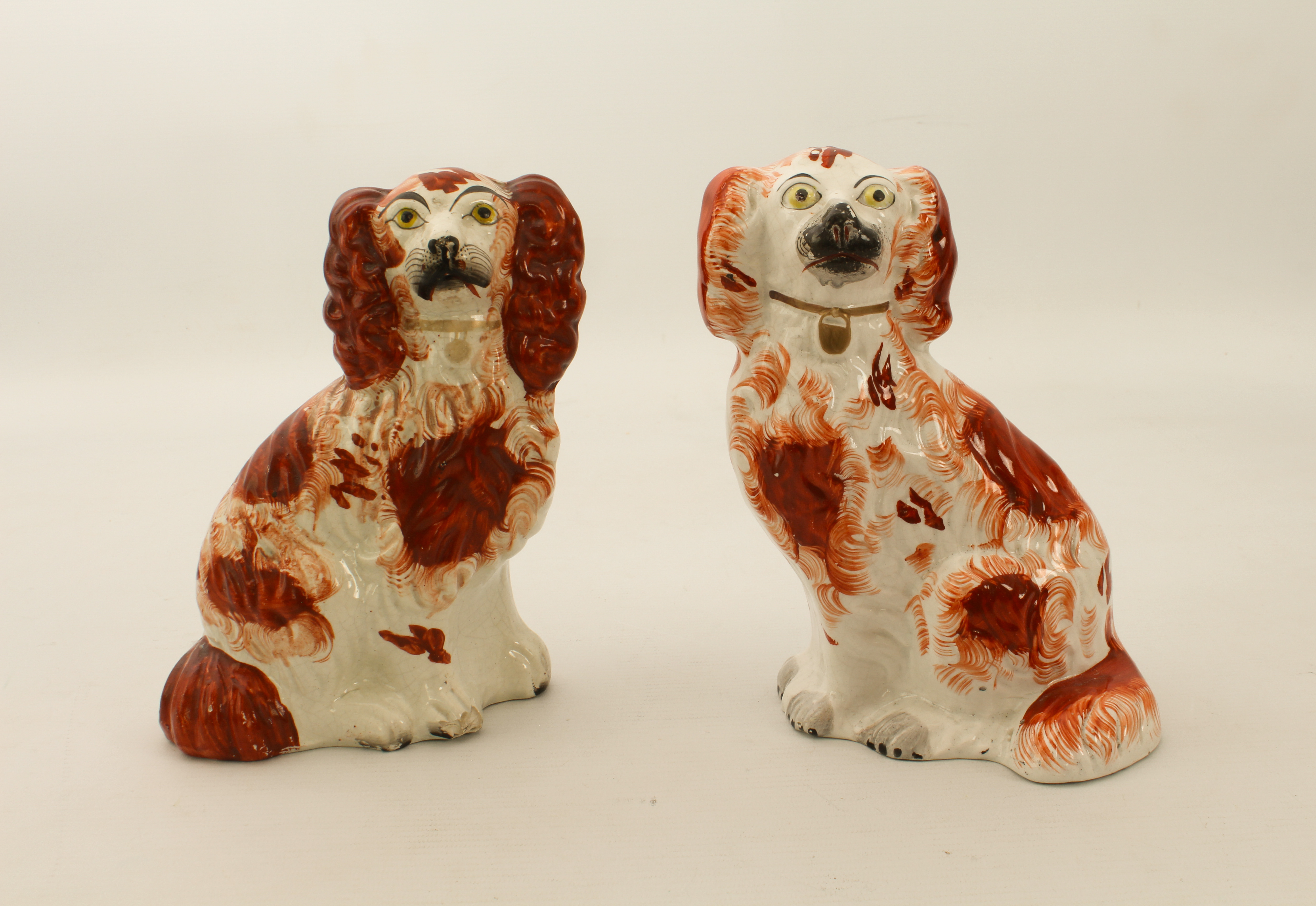 Two 19th century small Staffordshire pottery dogs - 19.2 cm high, one chipped to front paw.