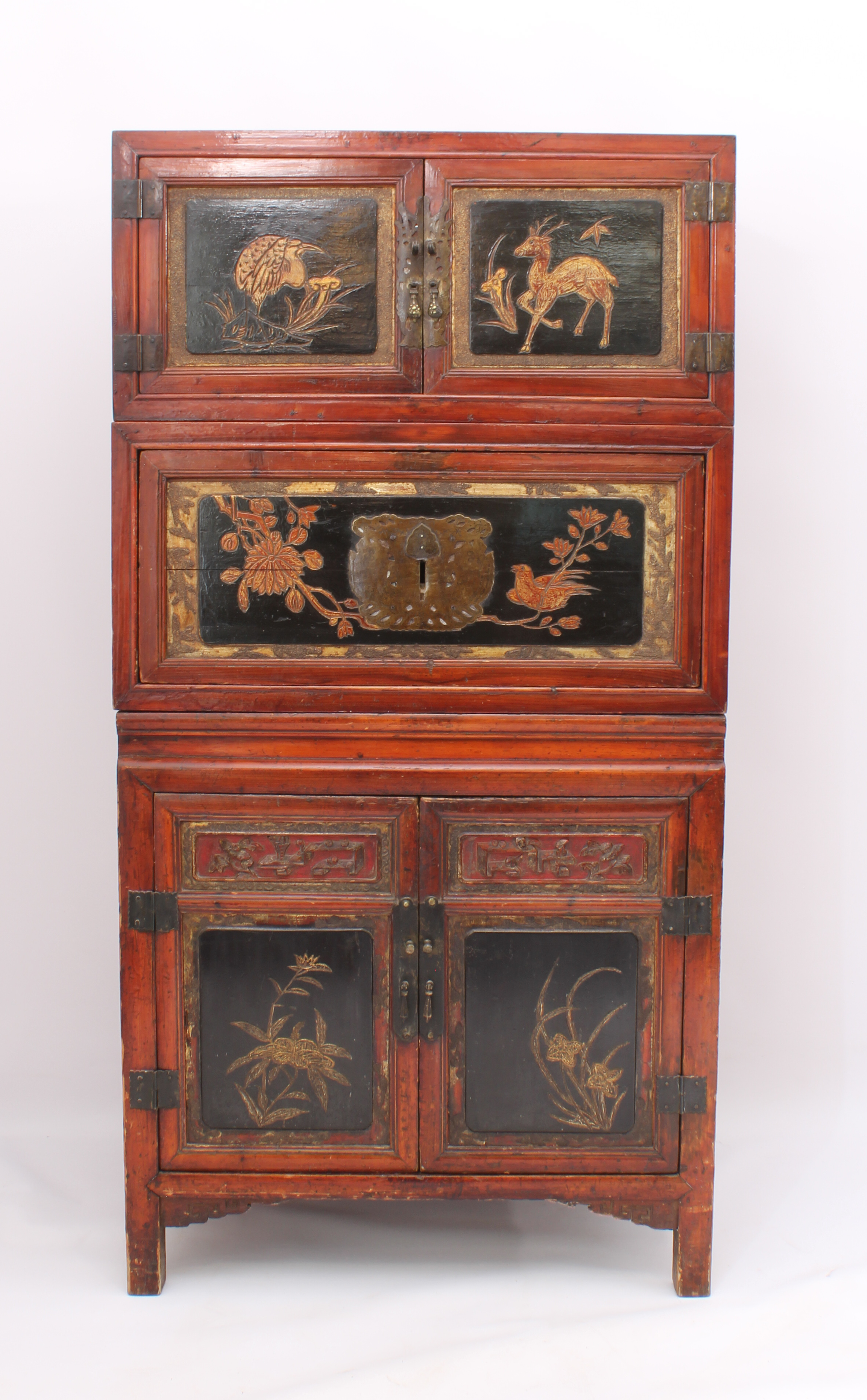 A Chinese red stained pine, lacquered and parcel-gilt three-piece compound cabinet - probably