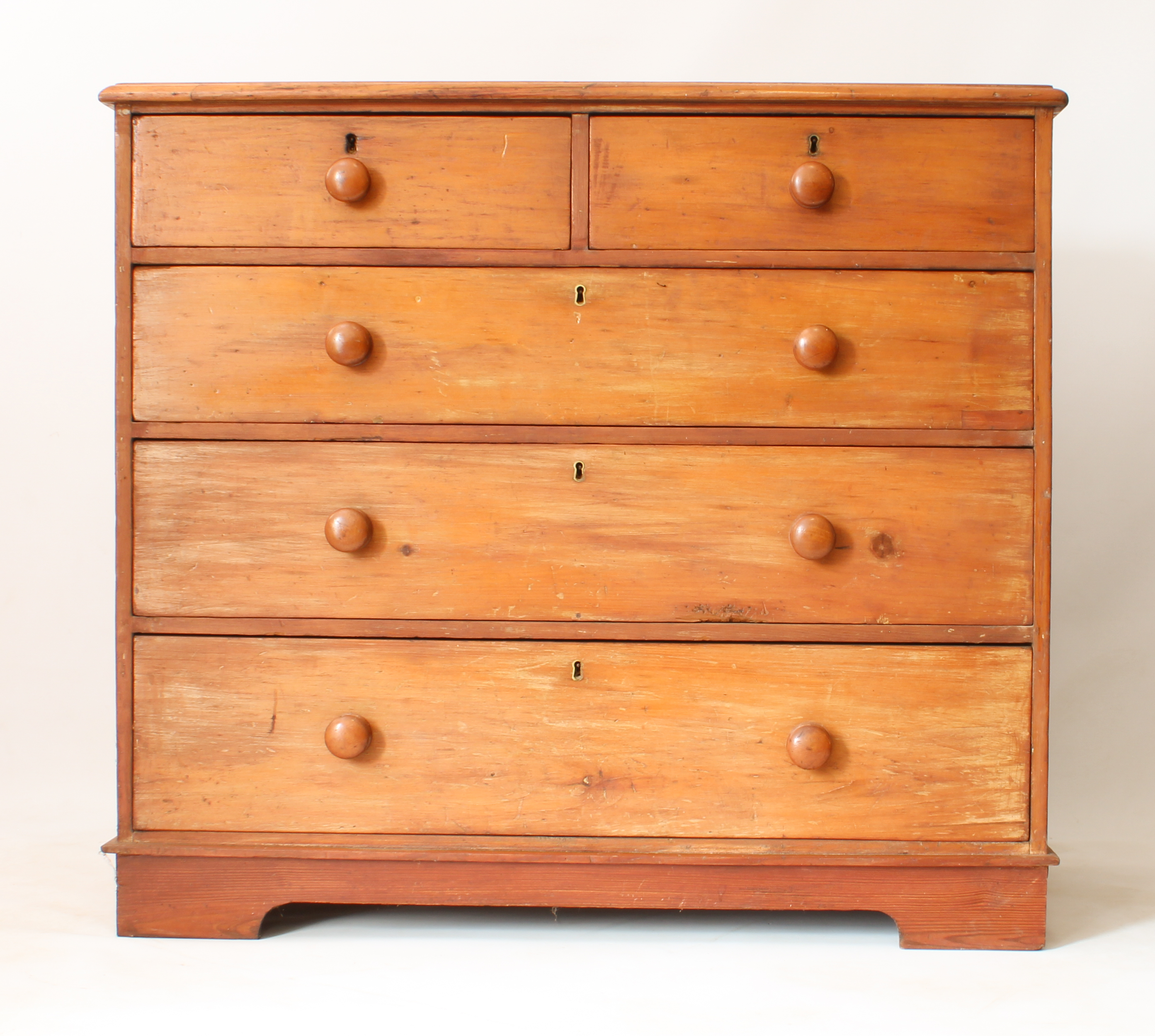 A Victorian pine chest of drawers - the moulded top over two short and three long graduated drawers,