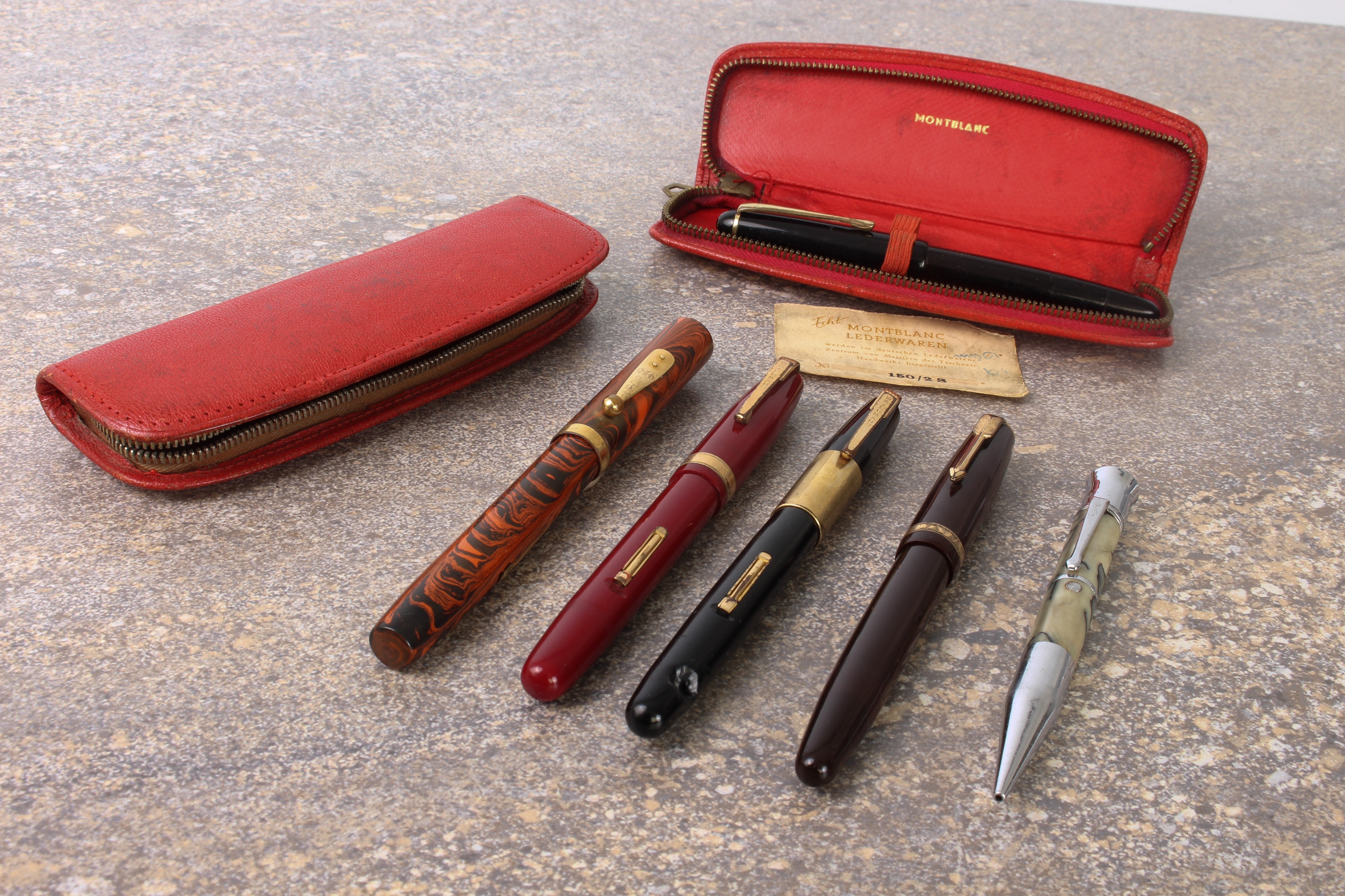 Five vintage fountain pens and a propelling pencil: a Mont Blanc 342 piston filler with red