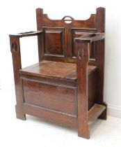 An early 20th century oak Arts & Crafts style monk's bench - the two panel back flanked by pierced