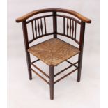 An Edwardian beech wood spindle-back corner chair - with horseshoe arms and rush seat, on square