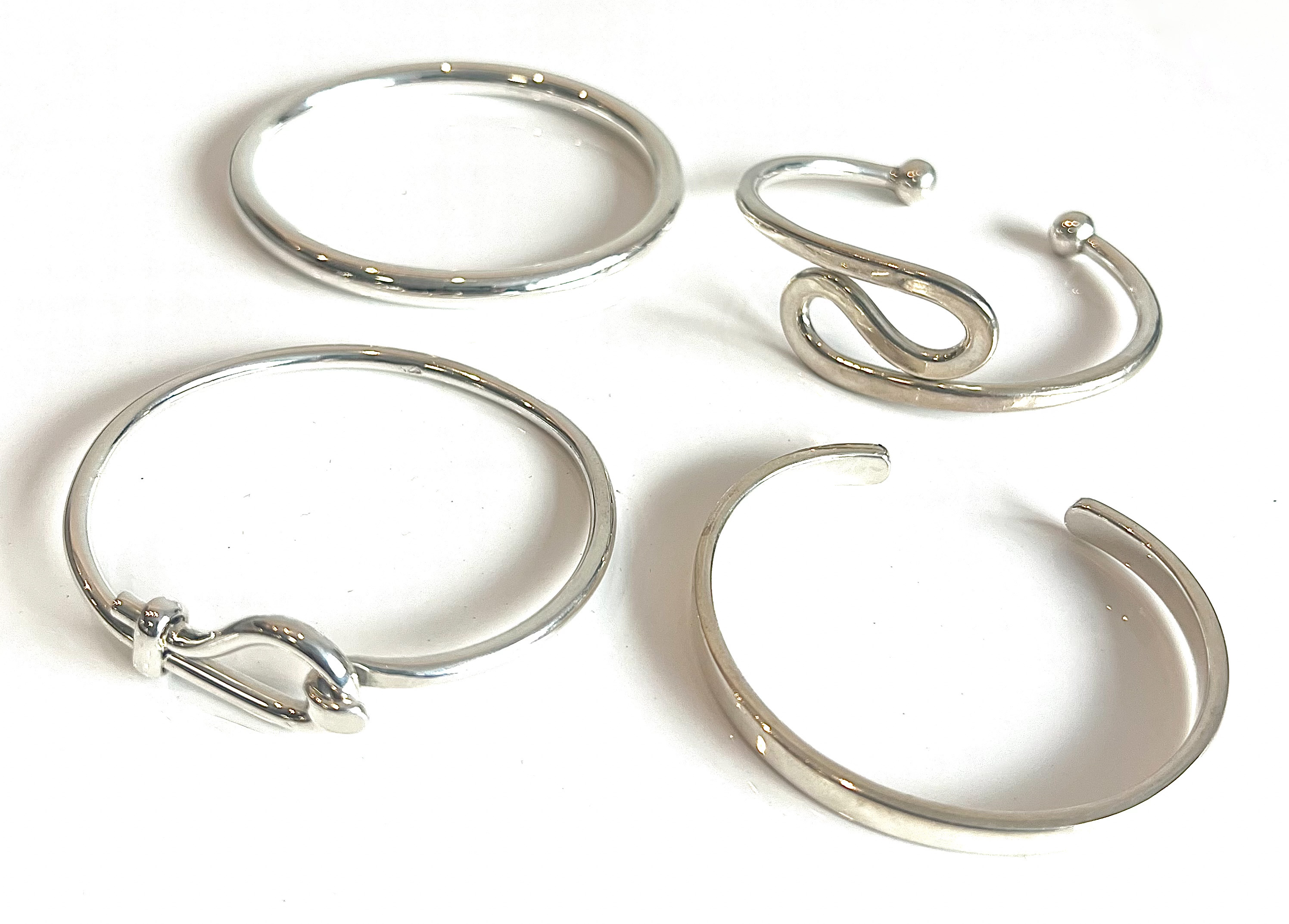 Four sterling silver bangles - each stamped 925, one Birmingham hallmarked.