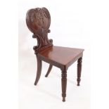 A William IV carved mahogany hall chair - the heart shaped balloon back carved with reeded