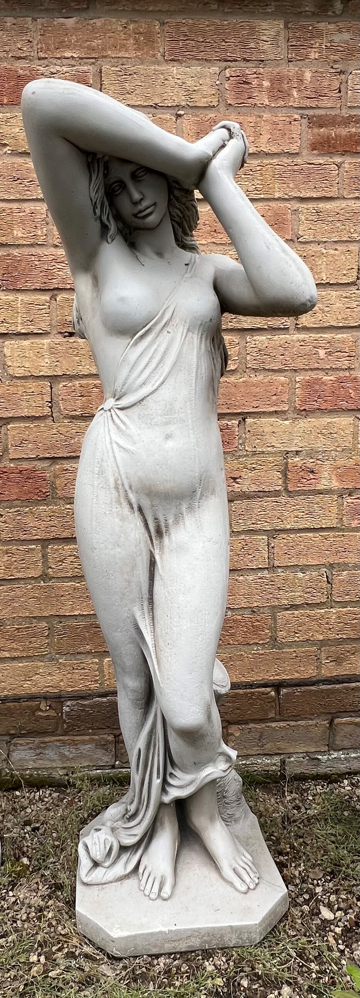 A moulded stone garden statue of a female with elbow aloft - 113cm high.