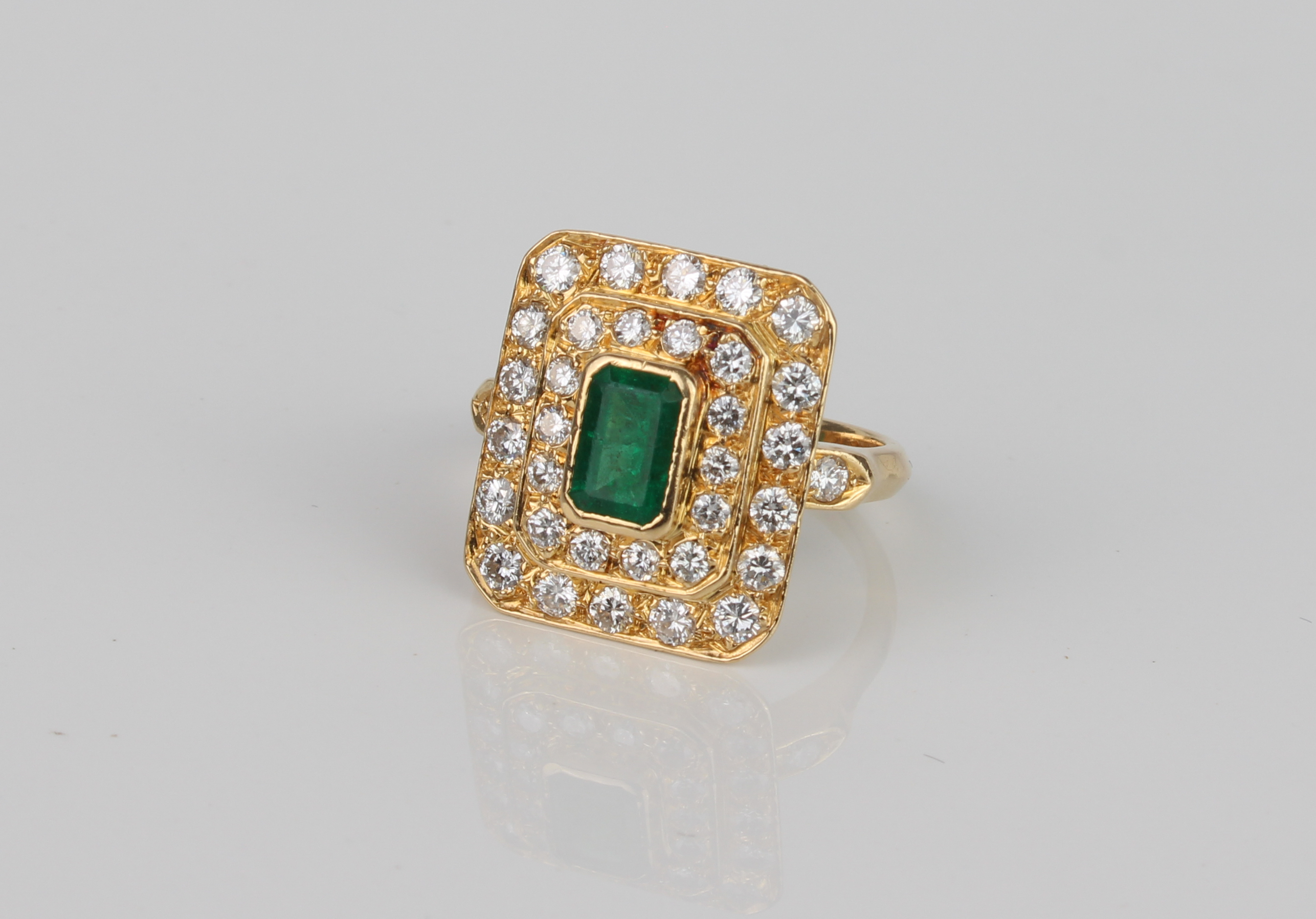 A French 18ct gold, emerald and diamond cluster ring - with French eagle's head mark, the 6.5 x 4.