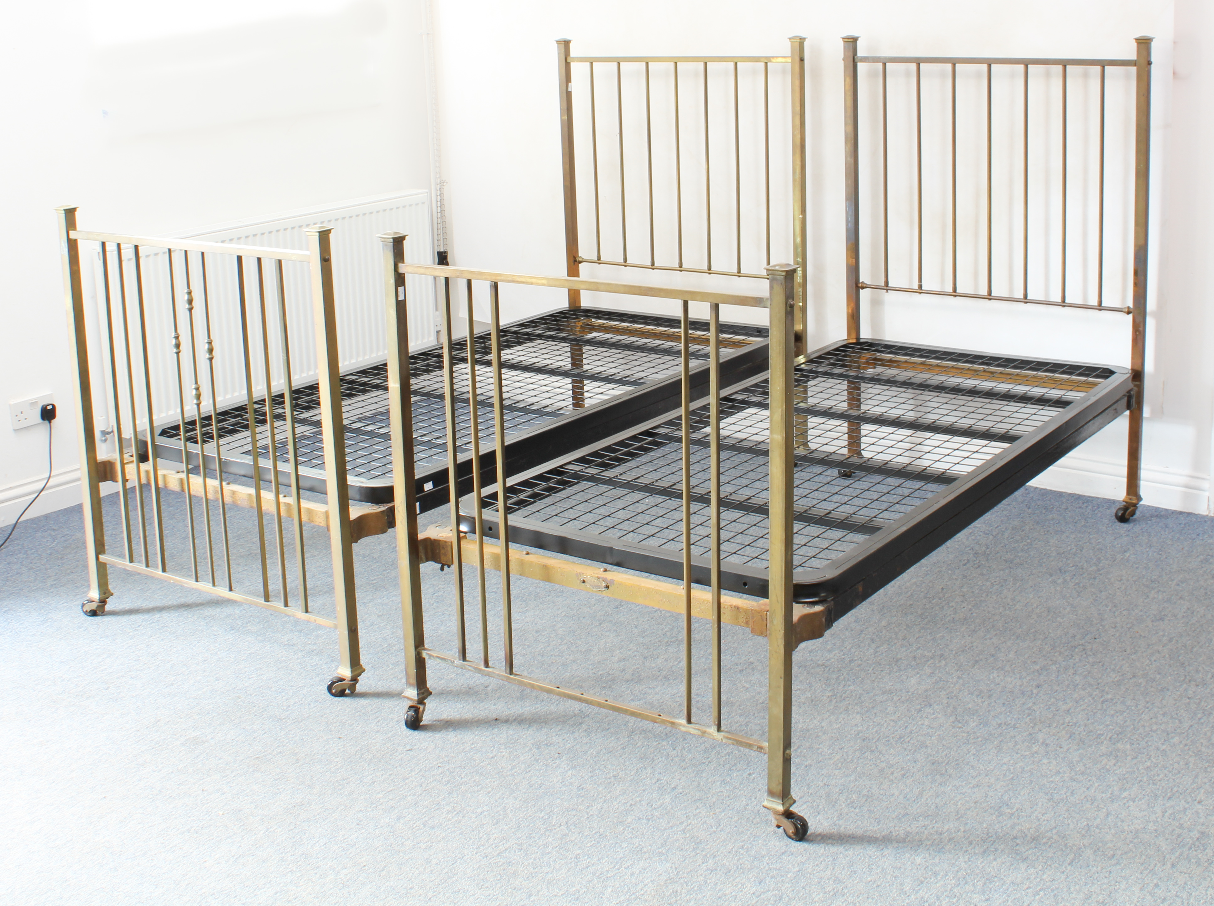 A pair of brass single beds by Heal & Sons (Heals) - 1920s-30s, the head and foot boards with square