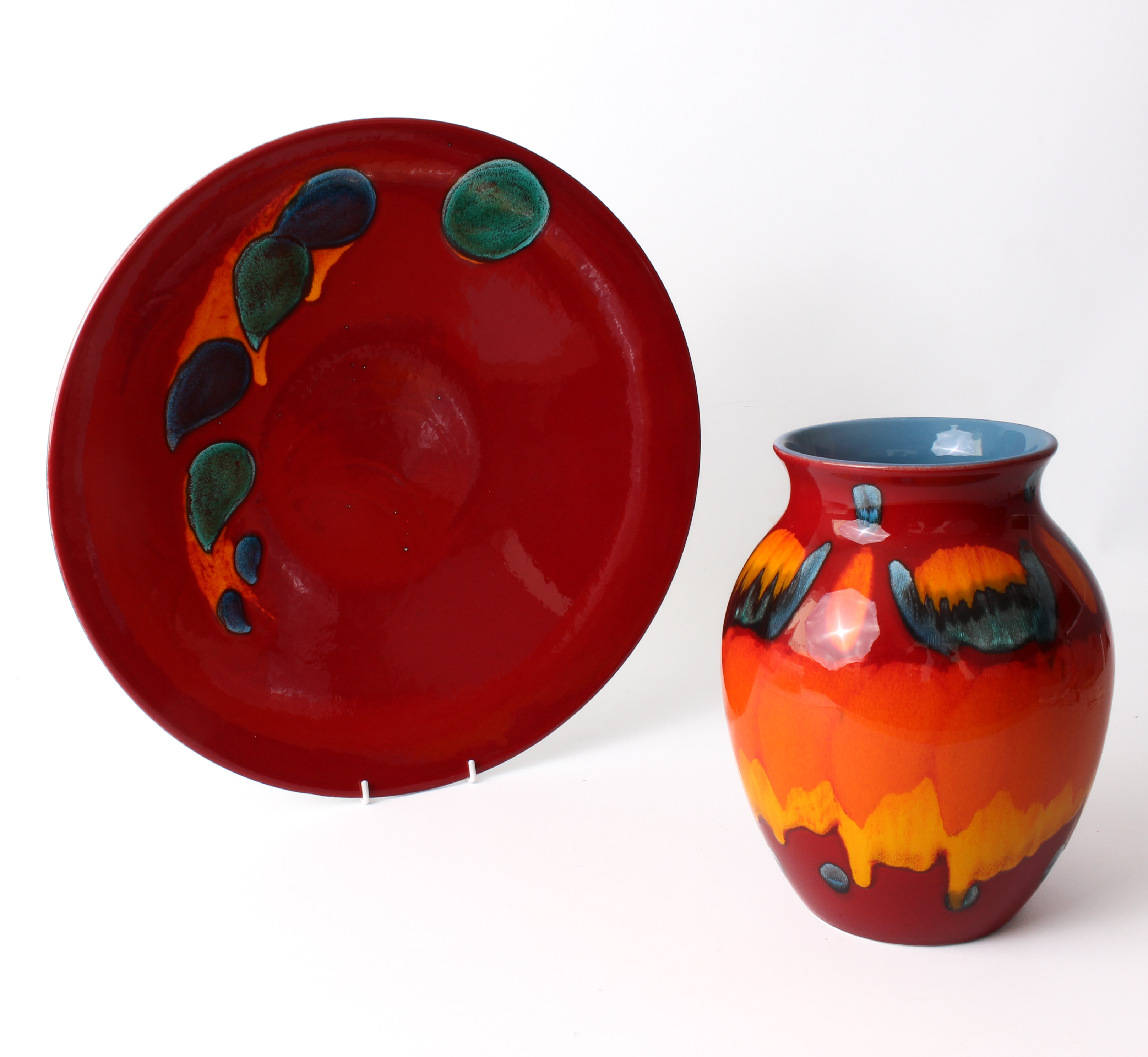 Two pieces of modern Poole Pottery - comprising a large Odyssey charger, glazed in deep red with