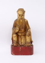 A Chinese carved and gilded wooden deity figure - probably early 20th century, with red lacquered