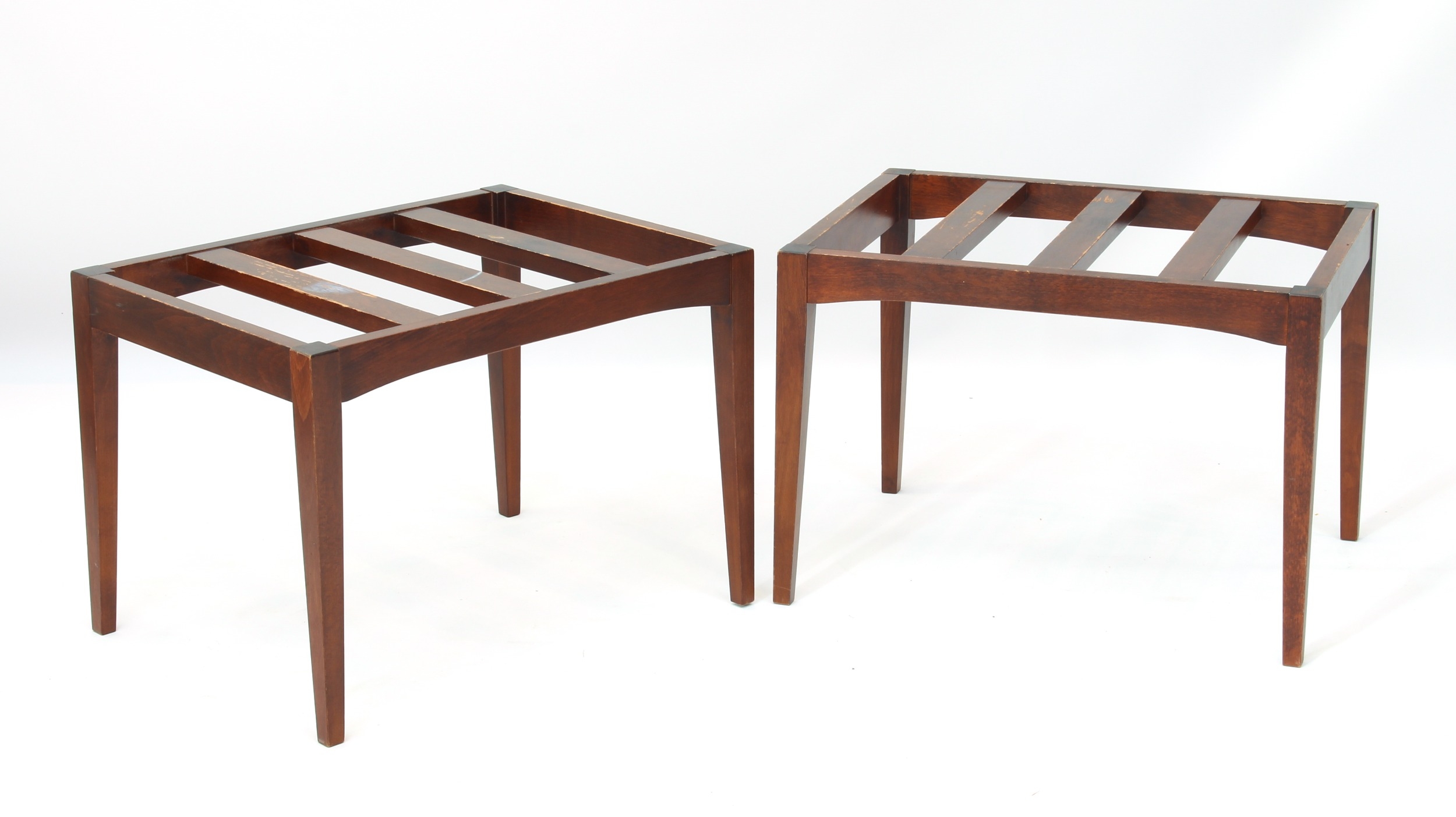 A pair of stained beech slat-top luggage racks - raised on square tapered supports (LWH 58.5 x 43