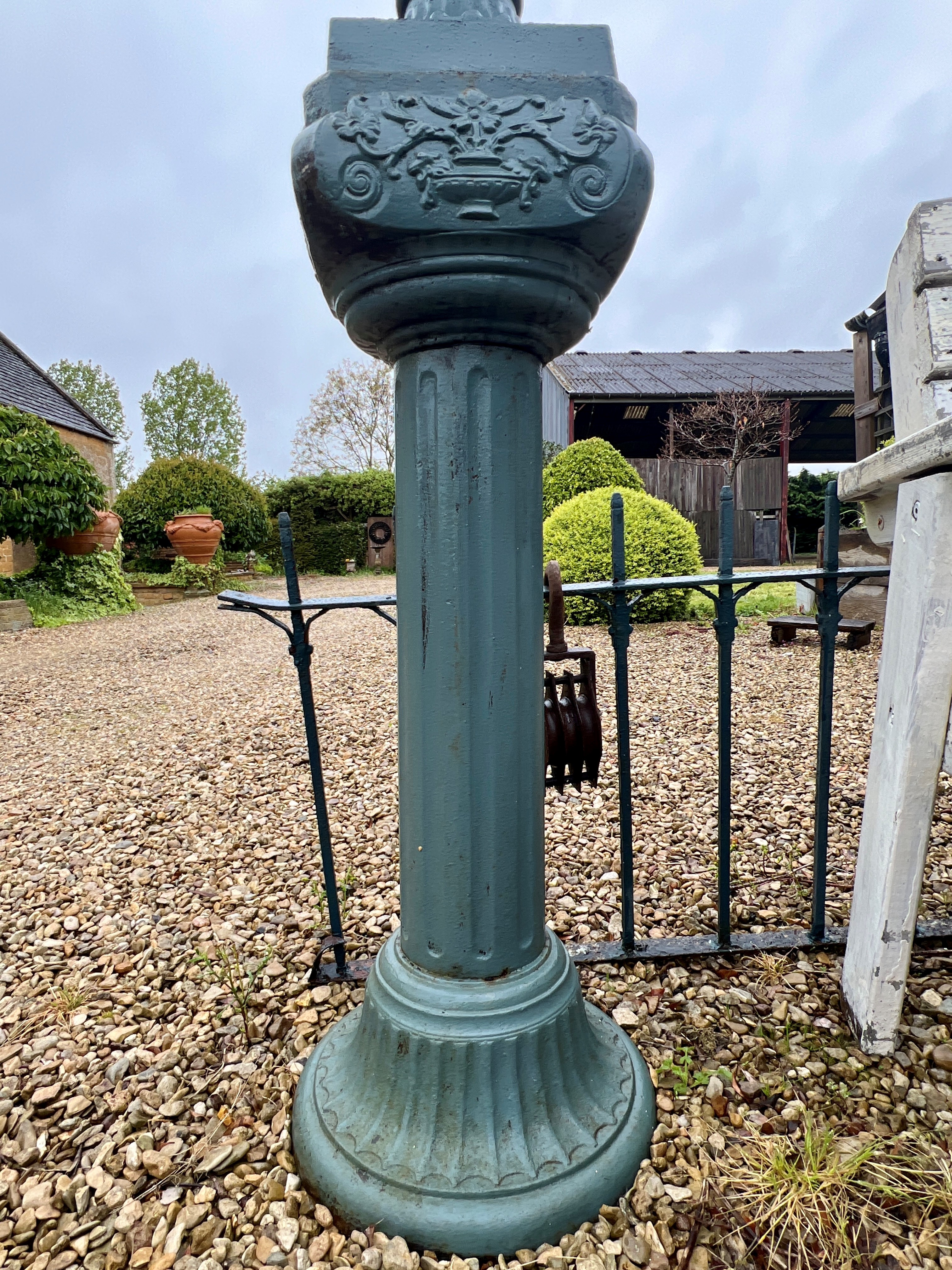 A pair of cast iron urns on column pedestals - painted dark green, the urns 57cm diameter, 72cm - Image 4 of 4