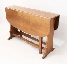 A 1930s oak dropleaf breakfast or small dining table - the top opening on gatelegs, raised on shaped