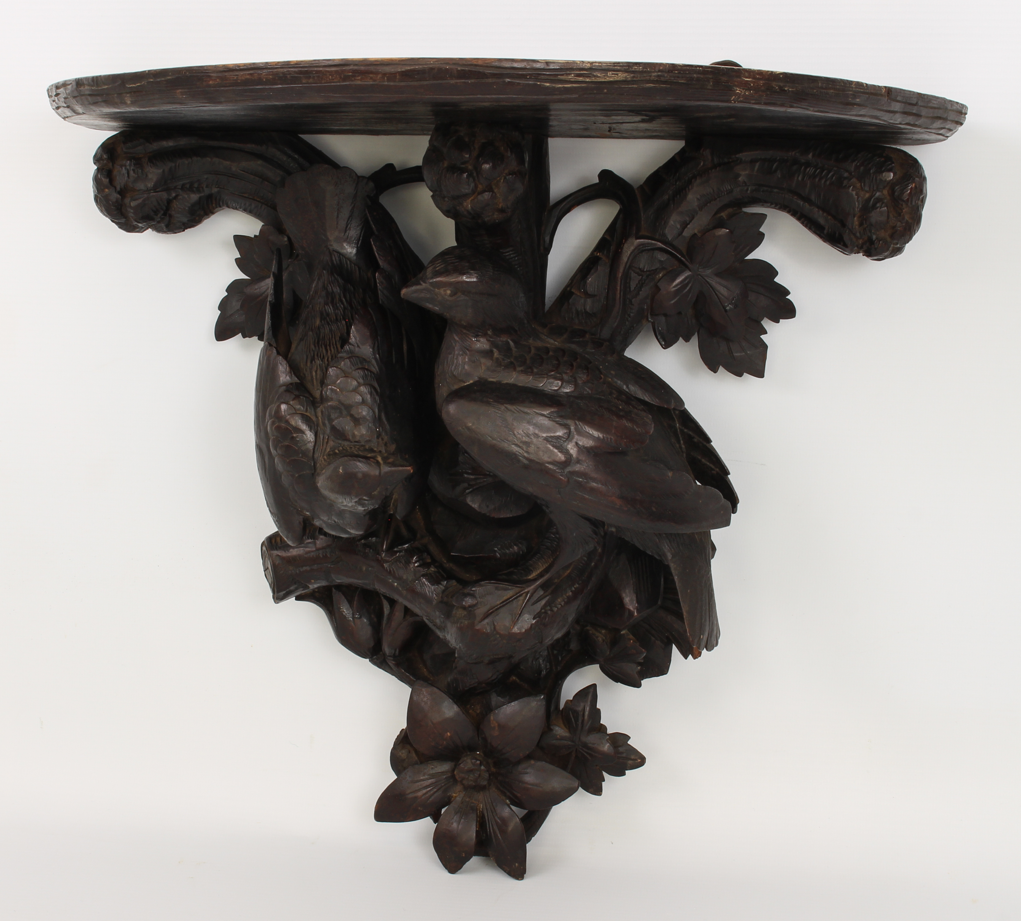 A late 19th century French carved and ebonised wooden clock bracket - probably lime wood, the demi-