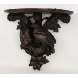 A late 19th century French carved and ebonised wooden clock bracket - probably lime wood, the demi-