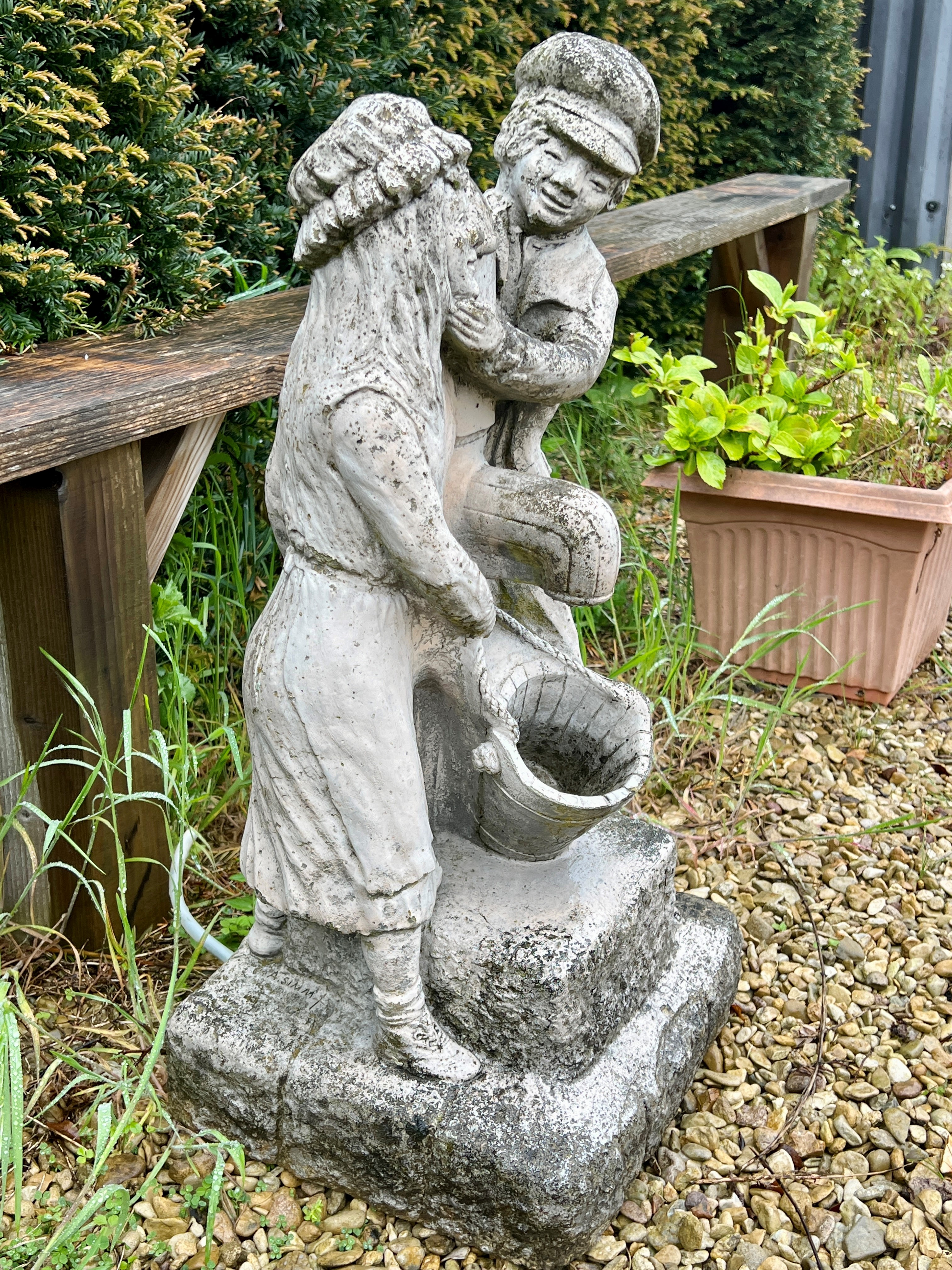 A composite stone water feature - depicting a couple standing beside a water tap, 76cm high. - Image 2 of 3