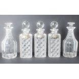 Seven cut glass decanters - a trio of early 20th century square hobnail cut tantalus decanters