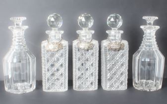 Seven cut glass decanters - a trio of early 20th century square hobnail cut tantalus decanters