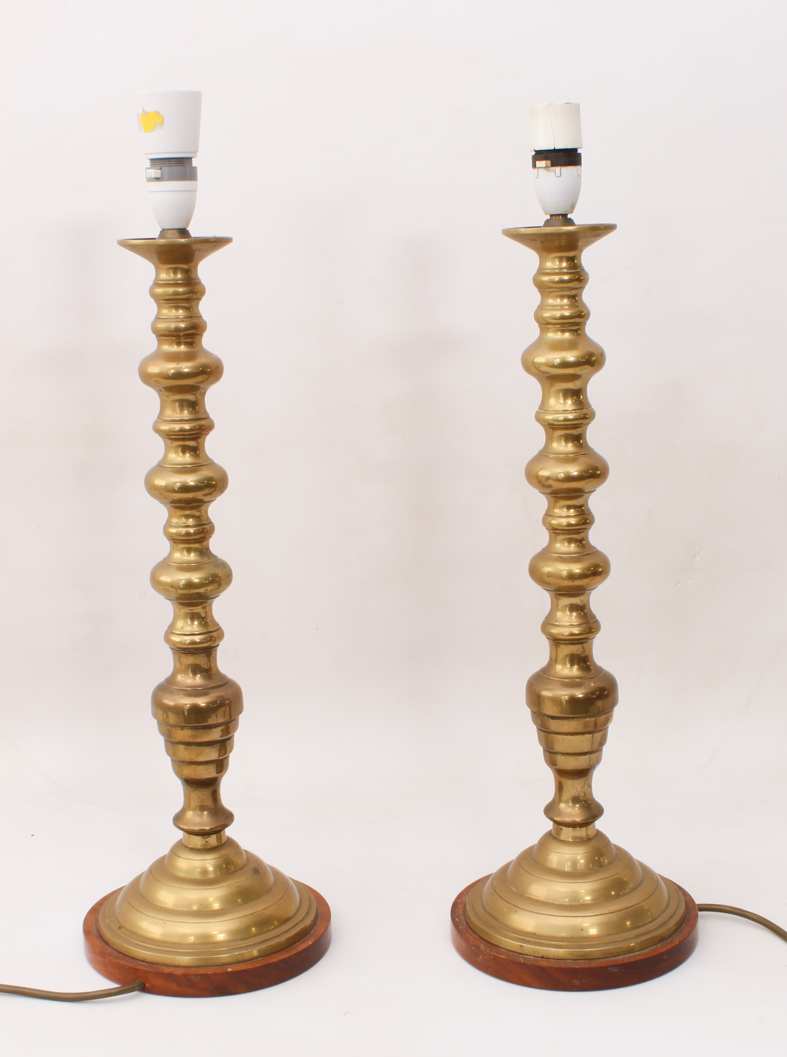 A pair of tall brass candlestick lamps in 19th century style - with knopped stems and stepped,