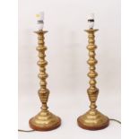 A pair of tall brass candlestick lamps in 19th century style - with knopped stems and stepped,