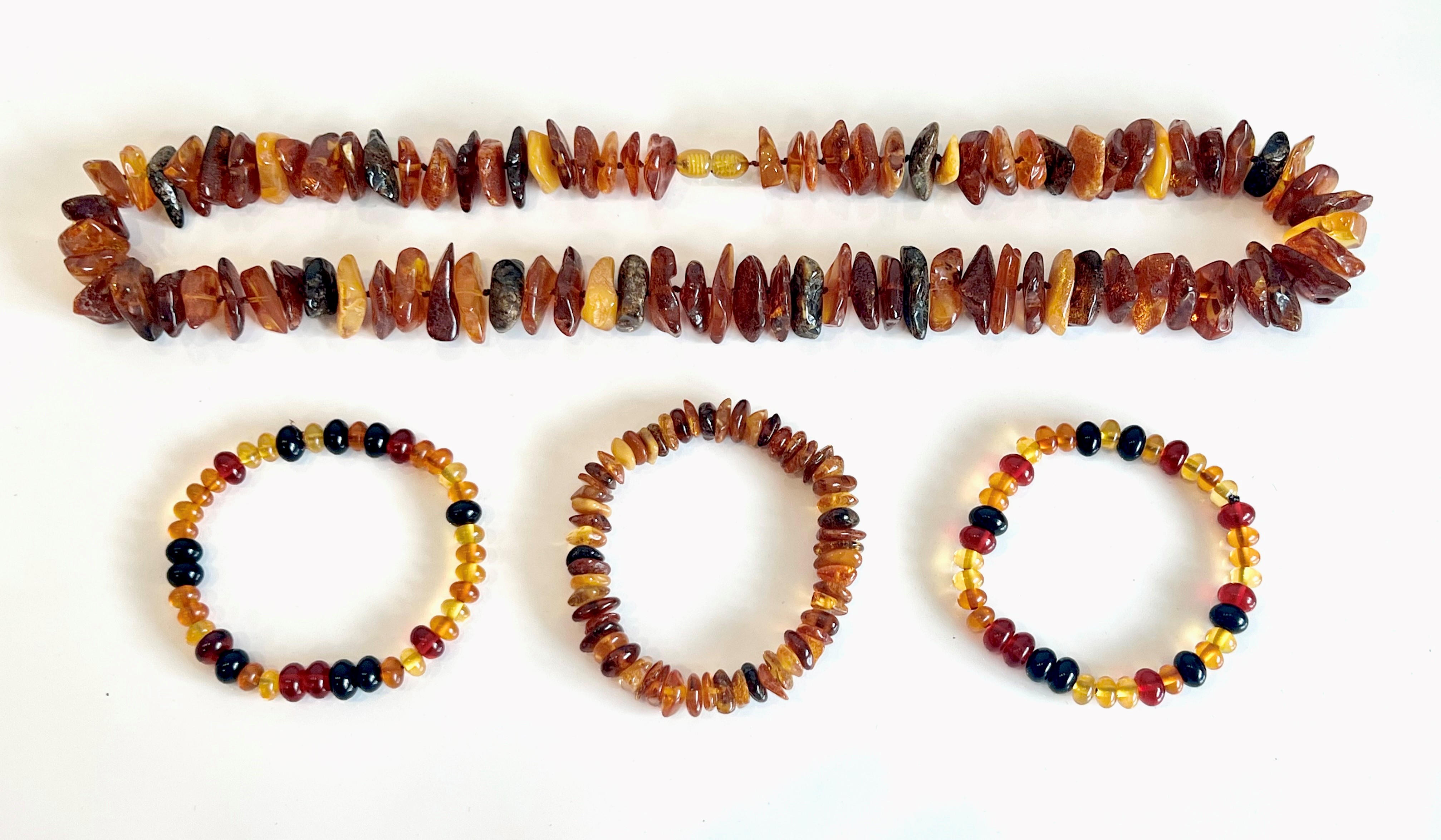 A Baltic amber necklace - with naturalistic beads in various colours, with screw clasp, 62.5 cm